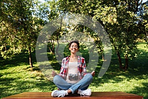 Woman photographer sitting outdoors in park meditate