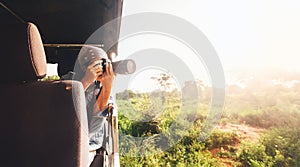 Woman photographer takes a picture with professional camera from