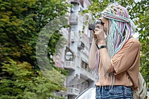 Woman photographer takes pictures while walking in the old city.