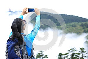 Woman photographer taking photo at emei mountain peak