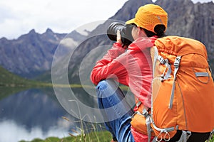 Woman photographer taking photo in mountains