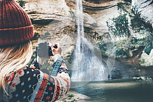 Woman photographer taking photo of waterfall