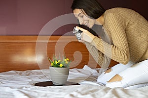 Woman photographer taking photos with her camera of some yellow flowers