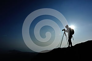 Woman photographer taking photos at mountain peak