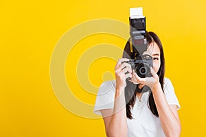 Woman photographer taking picture and looking viewfinder on digital mirrorless photo camera