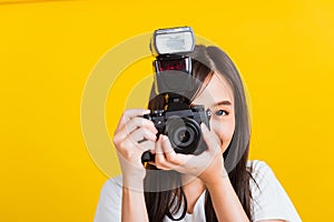 Woman photographer taking picture and looking viewfinder on digital mirrorless photo camera