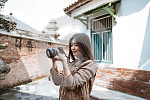 Woman photographer taking picture using camera