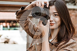 Woman photographer taking picture using camera