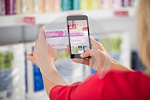 Woman Photographing Capsule Packet In Store