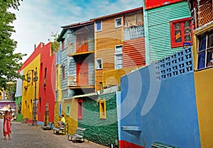 Woman photographing a child in front of colorful buildings of the Argentinean district La Boca, in Buenos Aires, during photo