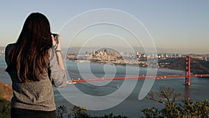 Woman photographing the Golden Gate Bridge, San Francisco