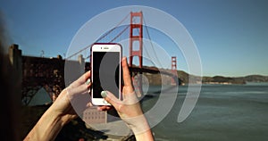 Woman photographing the Golden Gate Bridge, San Francisco