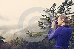 Woman photographing mountains while on a hike