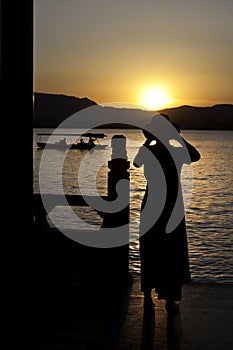 Woman photographing the sunset, West Lake, Hangzhou