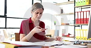 Woman photographs financial report in office charts