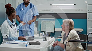 Woman with physical impairment analyzing x ray scan with doctor