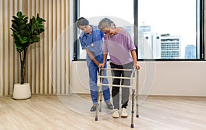 Woman physical therapist in blue uniform help an elderly to exercise and practice walking on walker or cane. Healthcare and