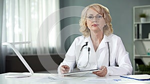 Woman physician with tablet hands, online consultation of patient, technologies