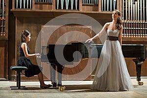 Woman pianist plays the piano and beautiful singer photo