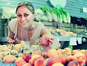 Una mujer cosecha aromático duraznos 