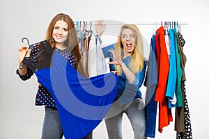 Woman picking clothes in wardrobe, friend being jealous