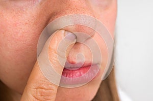 Woman is picking her nose with finger inside