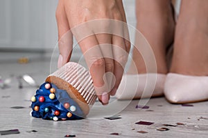 Woman picking up dropped cupcake from floor, closeup. Troubles happen