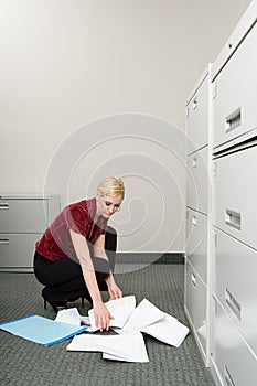 Woman picking up dropped paper photo