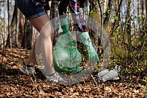 Woman picking up dump on dirty forest