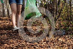 Woman picking up dump on dirty forest