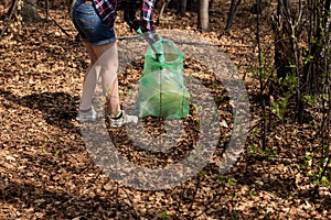 Woman picking up dump on dirty forest