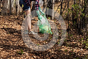 Woman picking up dump on dirty forest