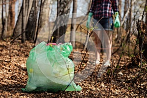 Woman picking up dump on dirty forest