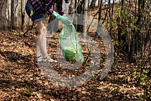 Woman picking up dump on dirty forest