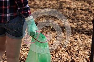 Woman picking up dump on dirty forest