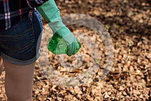 Woman picking up dump on dirty forest