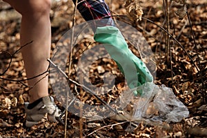 Woman picking up dump on dirty forest