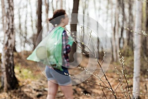 Woman picking up dump on dirty forest