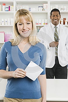 Woman Picking Up Prescription Drugs At Pharmacy