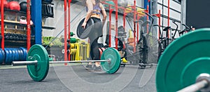 Woman picking up weightlifting discs in the gym