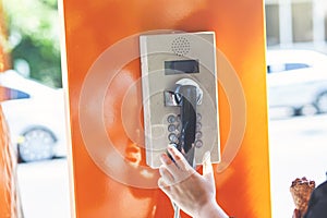 Woman picks up the city payphone