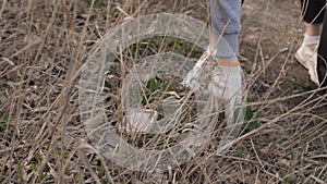 Woman picks up garbage in from the ground