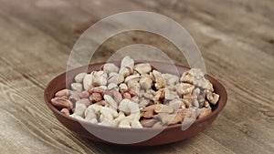 Woman Picks Up a single Cashew, To Eat, From Her Bowl. took a nut on the left side