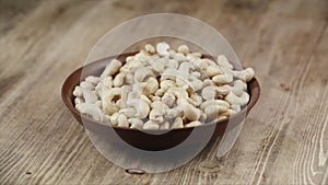 Woman Picks Up A Single Cashew, To Eat, From Her Bowl. took a nut on the right side