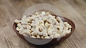 Woman Picks Up A Single Cashew, To Eat, From Her Bowl. took a nut on the right side