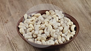 Woman Picks Up A Single Cashew, To Eat, From Her Bowl. took a nut on the right side