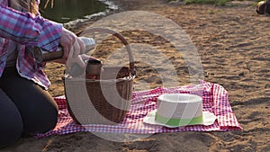 Woman with picnic basket and thermos flask on the beach sand