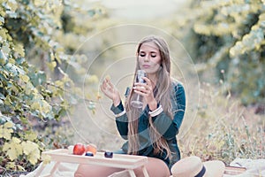 Woman picnic vineyard. Happy woman with a glass of wine at a picnic in the vineyard, wine tasting at sunset and open