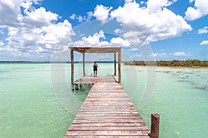 Woman on pier in Caribbean Bacalar lagoon, Mexico