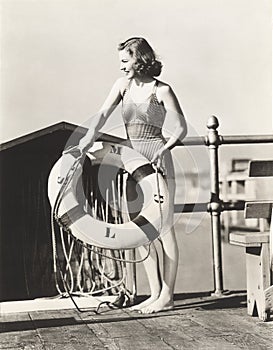 Woman on pier holding a life preserver